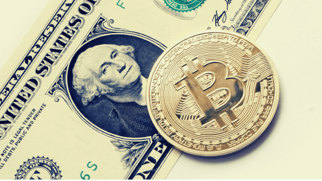 Imagem de uma cédula de dólar e Bitcoin