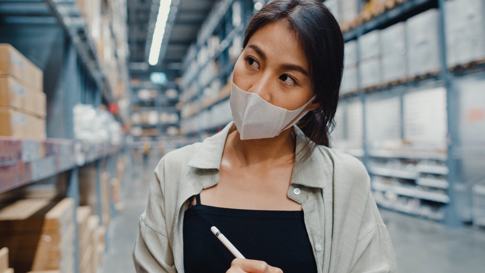 A imagem mostra uma mulher asiática inspecionando produtos